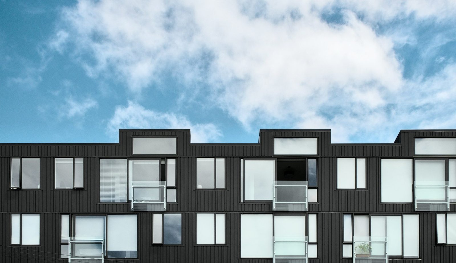 A modern New York apartment building facade against an open sky.